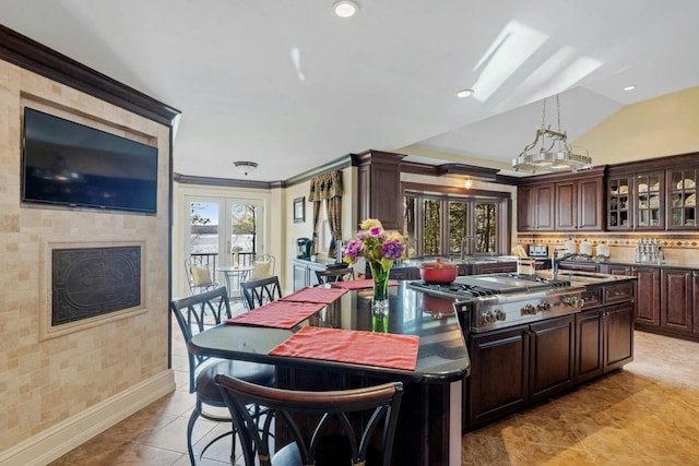 kitchen featuring french doors, sink, stainless steel gas cooktop, vaulted ceiling, and dark brown cabinets