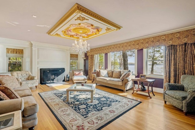 living room featuring light hardwood / wood-style flooring, crown molding, and an inviting chandelier