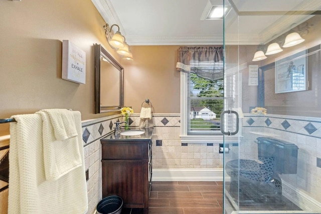 bathroom featuring walk in shower, vanity, tile walls, and crown molding