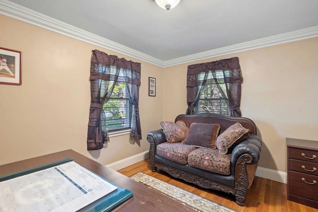 sitting room featuring light wood-type flooring, a wealth of natural light, and crown molding