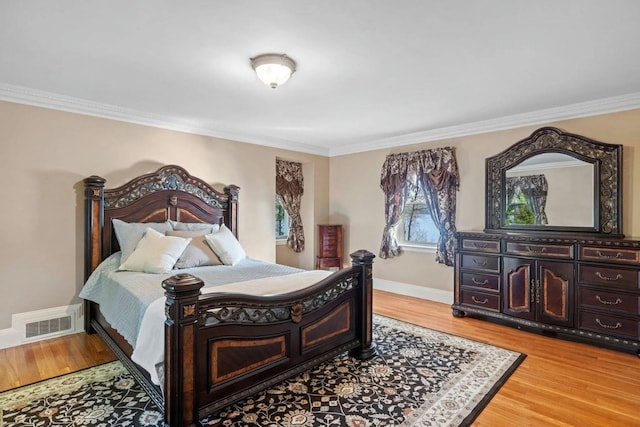 bedroom featuring ornamental molding and hardwood / wood-style flooring