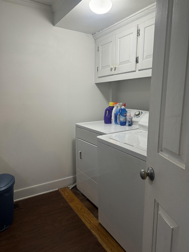 laundry area featuring washing machine and dryer, dark wood-type flooring, and cabinets