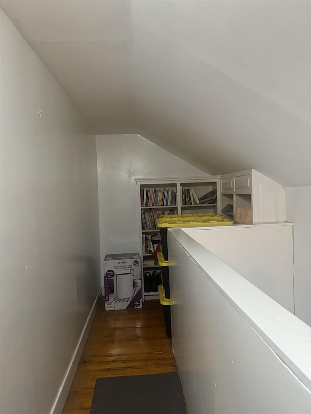 hall with dark hardwood / wood-style flooring and lofted ceiling