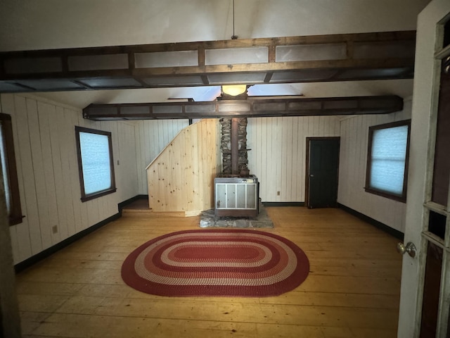 unfurnished living room with hardwood / wood-style floors and wooden walls