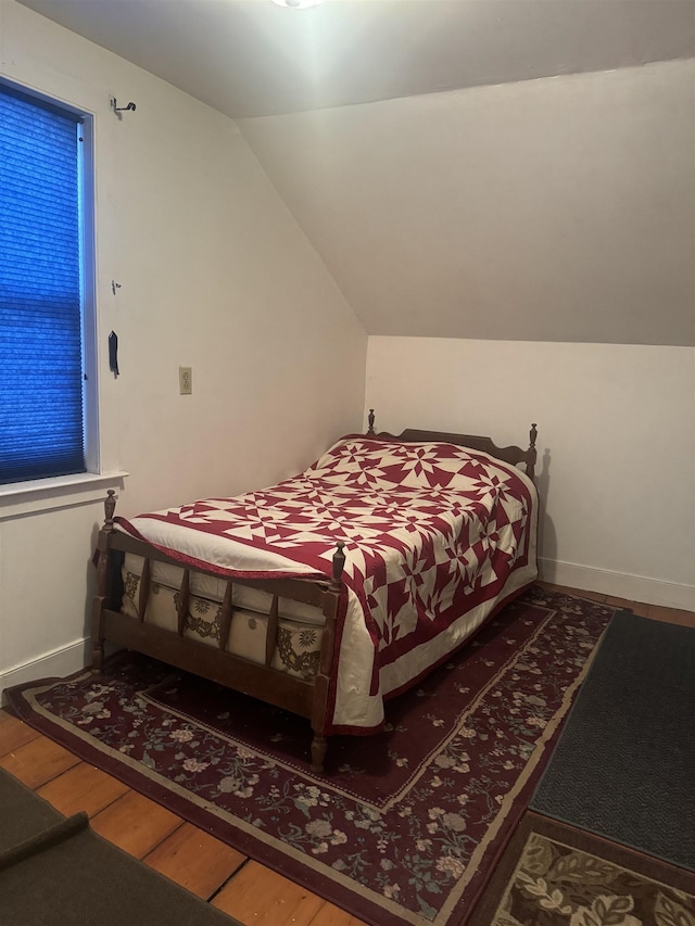 bedroom featuring wood-type flooring and vaulted ceiling