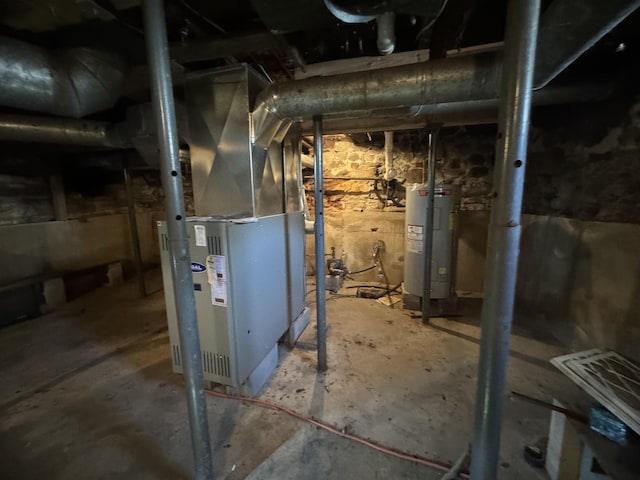 utility room featuring heating unit and water heater