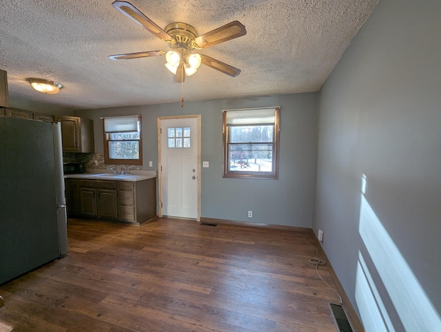 kitchen with sink, decorative backsplash, stainless steel fridge, ceiling fan, and dark hardwood / wood-style flooring