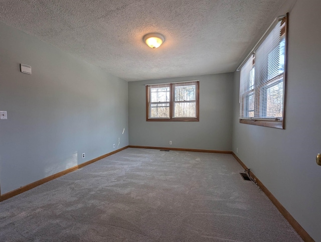 carpeted spare room featuring a textured ceiling