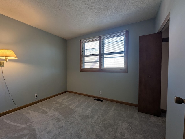 carpeted spare room with a textured ceiling