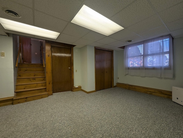 basement with a paneled ceiling and carpet floors