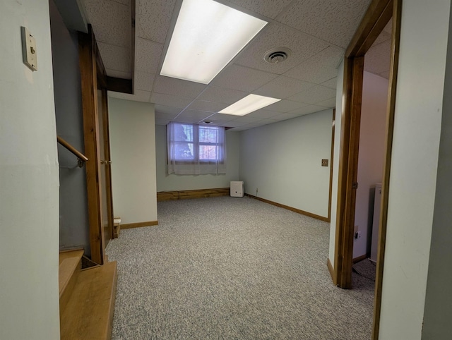 basement featuring a paneled ceiling and carpet floors