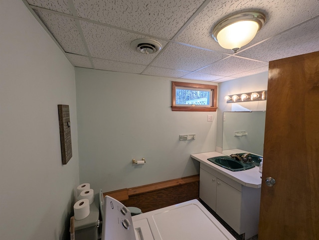 bathroom featuring a paneled ceiling and vanity