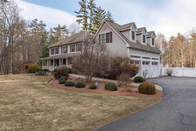 view of front facade with a front lawn, covered porch, and a garage