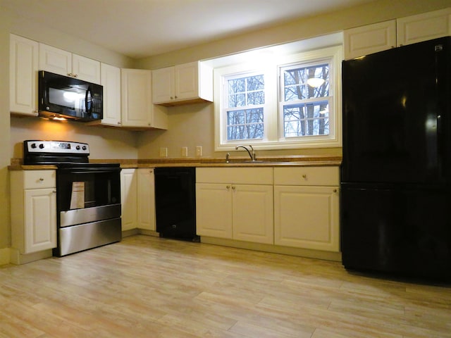 kitchen with sink, white cabinets, black appliances, and light hardwood / wood-style floors