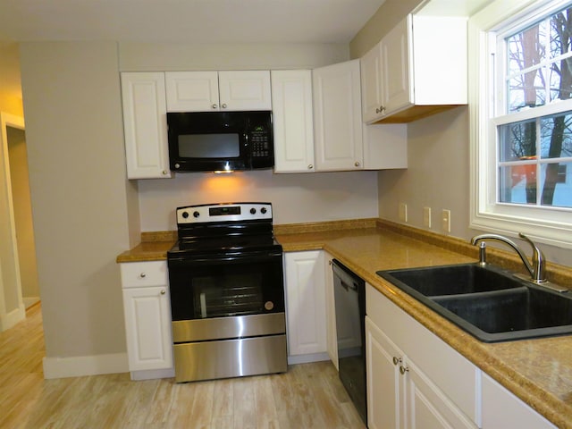 kitchen with black appliances, white cabinets, and sink