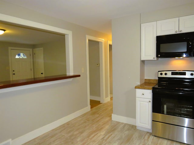 kitchen featuring light hardwood / wood-style floors, white cabinetry, and stainless steel range