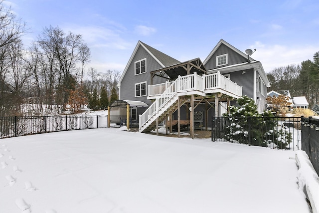 snow covered rear of property with a deck