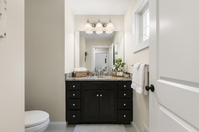 bathroom featuring tile patterned flooring, vanity, and toilet