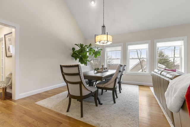 dining space with light hardwood / wood-style floors and lofted ceiling