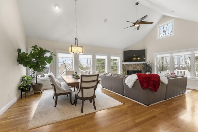 dining area with ceiling fan, a towering ceiling, and light hardwood / wood-style floors