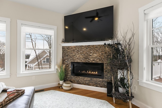 living room with a fireplace, hardwood / wood-style flooring, plenty of natural light, and lofted ceiling