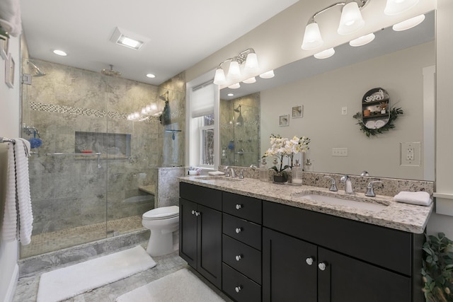 bathroom with vanity, toilet, and a shower with door