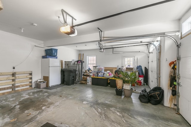 garage featuring a garage door opener and white refrigerator