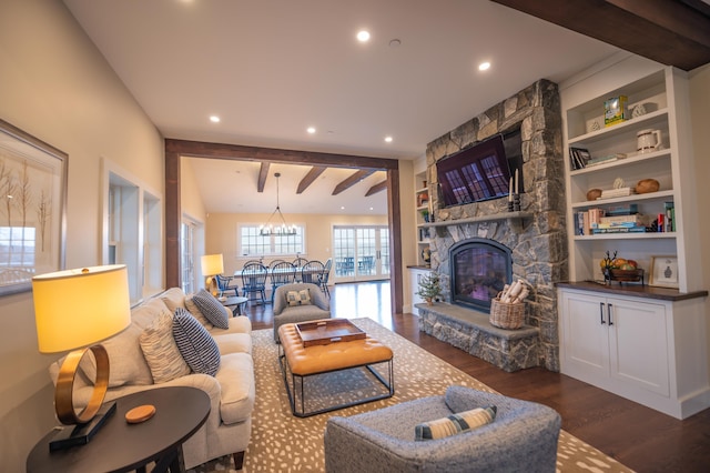 living room with a stone fireplace, built in features, beamed ceiling, dark hardwood / wood-style flooring, and an inviting chandelier