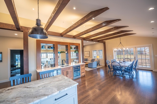 kitchen featuring decorative light fixtures, white cabinets, beverage cooler, a chandelier, and light stone countertops