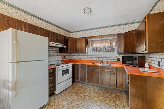 kitchen with dark brown cabinets, white appliances, and sink