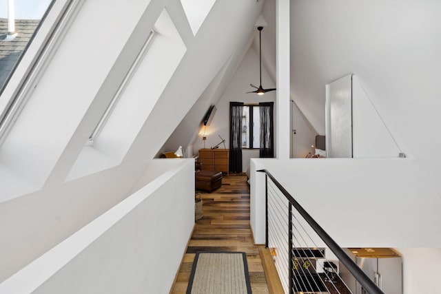 hallway featuring dark wood-type flooring and vaulted ceiling