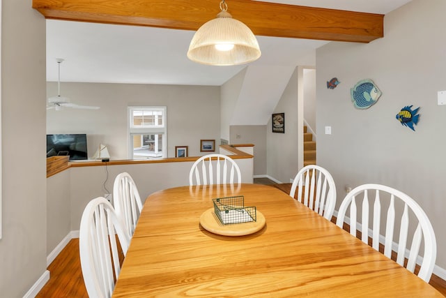 dining space with hardwood / wood-style floors, ceiling fan, and beam ceiling