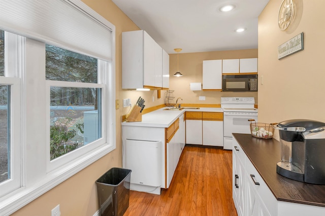 kitchen with white cabinetry, sink, hanging light fixtures, white range with electric stovetop, and light hardwood / wood-style floors