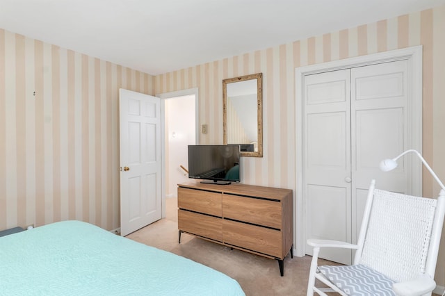 bedroom featuring light carpet and a closet