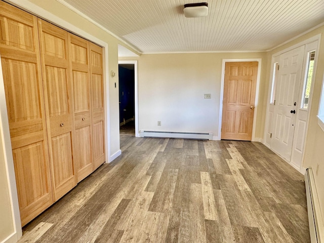 foyer featuring hardwood / wood-style floors, ornamental molding, and a baseboard heating unit