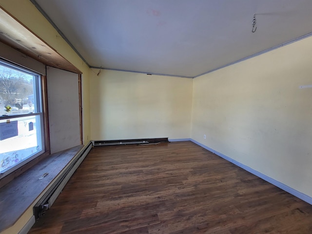 empty room featuring baseboard heating and dark wood-type flooring