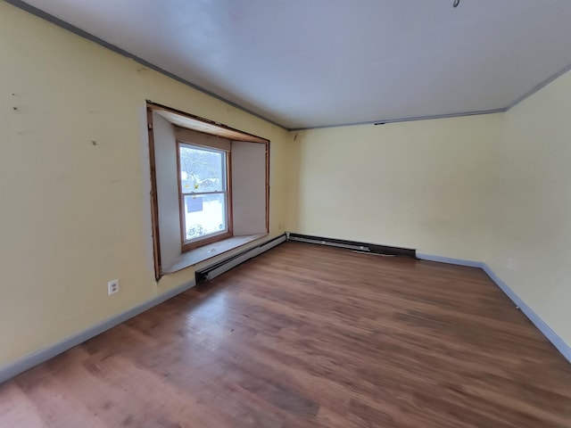 spare room with ornamental molding, a baseboard radiator, and hardwood / wood-style flooring