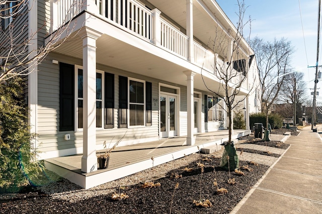 view of side of home featuring french doors and a porch