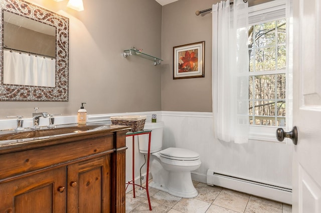 bathroom with tile patterned floors, vanity, toilet, and a baseboard heating unit