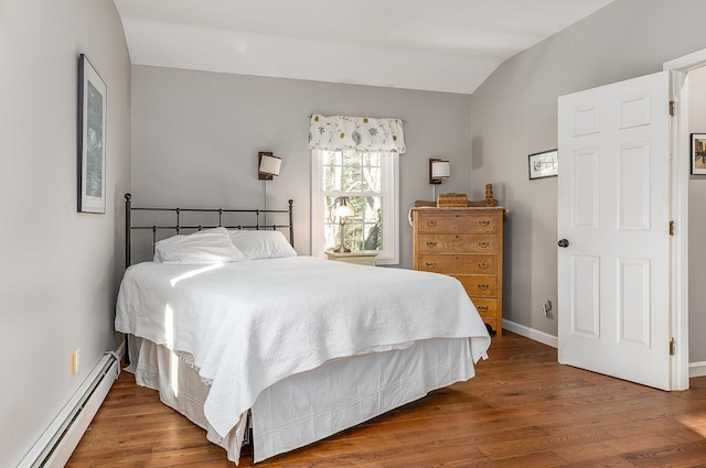 bedroom with wood-type flooring, a baseboard radiator, and vaulted ceiling