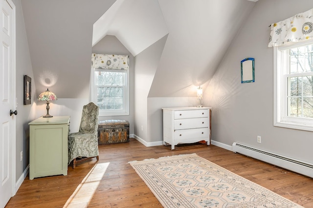 living area featuring a healthy amount of sunlight, a baseboard radiator, and light hardwood / wood-style floors