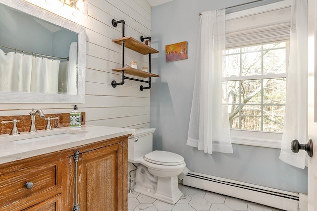 bathroom featuring vanity, wood walls, toilet, and a baseboard radiator