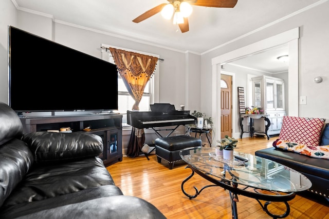 living room featuring ceiling fan, ornamental molding, and light hardwood / wood-style flooring