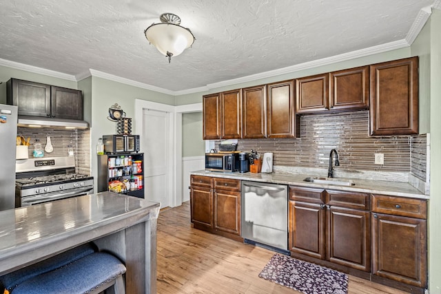 kitchen featuring appliances with stainless steel finishes, backsplash, ornamental molding, and sink