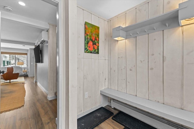 mudroom with a wall mounted air conditioner, dark hardwood / wood-style flooring, and wooden walls