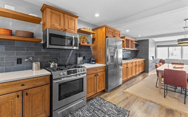 kitchen featuring decorative backsplash, light wood-type flooring, and appliances with stainless steel finishes