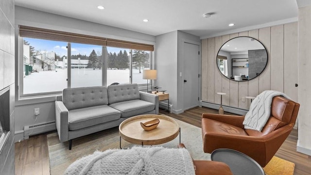 living room with wood-type flooring, a baseboard radiator, and a healthy amount of sunlight