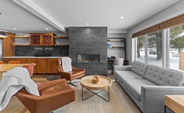 living room featuring a tile fireplace and bar area