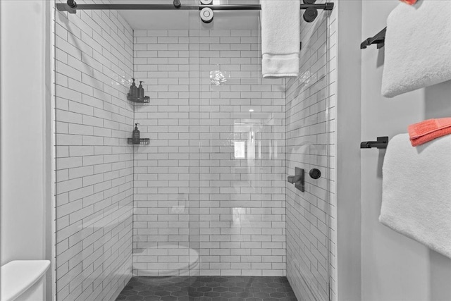 bathroom with tiled shower and toilet