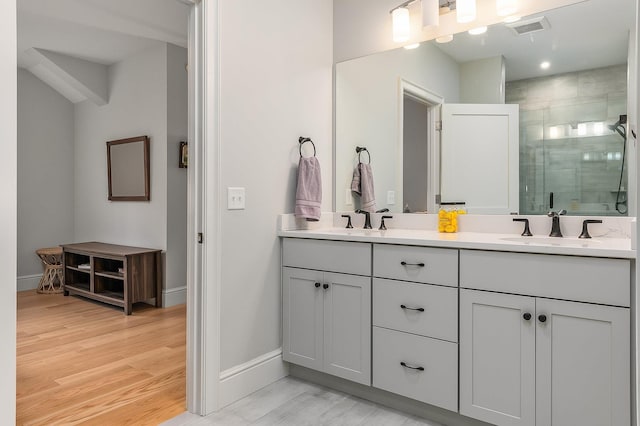 bathroom with hardwood / wood-style floors, vanity, and walk in shower